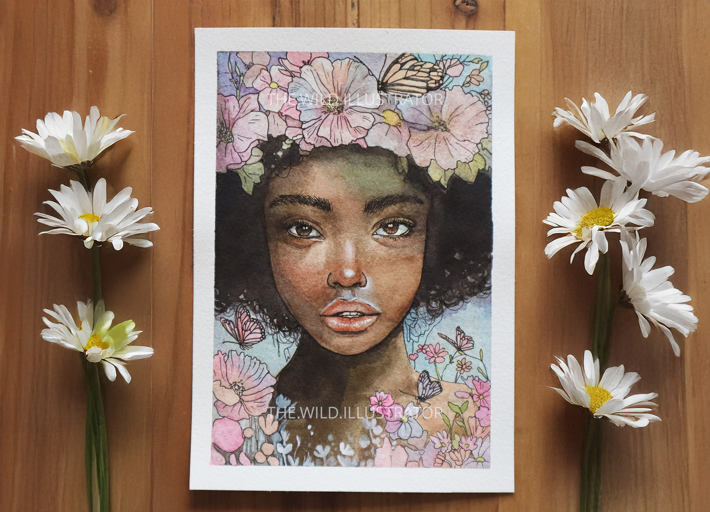 Hand-painted watercolor mini-painting of a Black woman surrounded by vibrant spring flowers, symbolizing renewal and nature’s beauty.