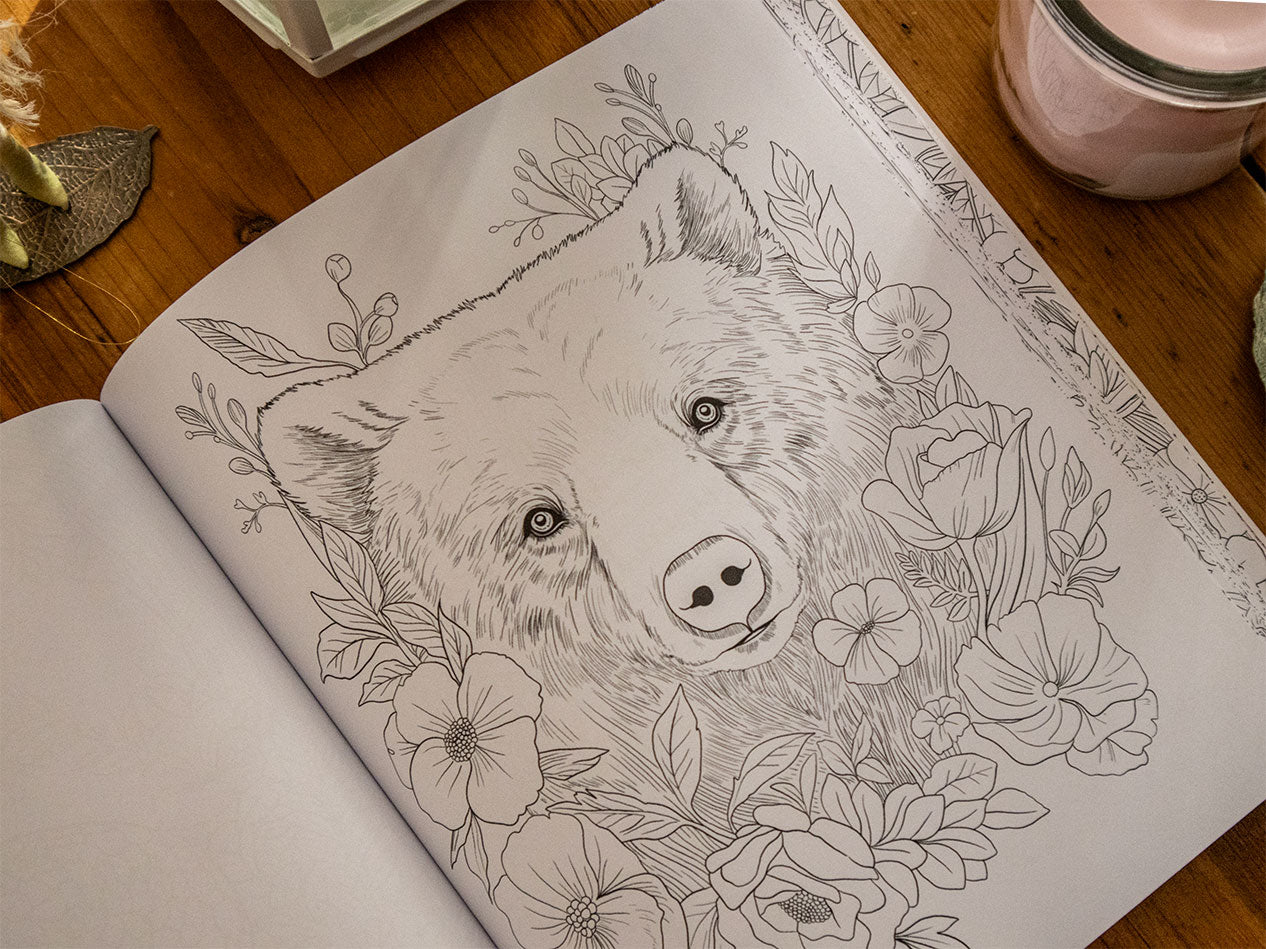 Page from Zauberhafte Ausmalwelten featuring a bear surrounded by flowers.