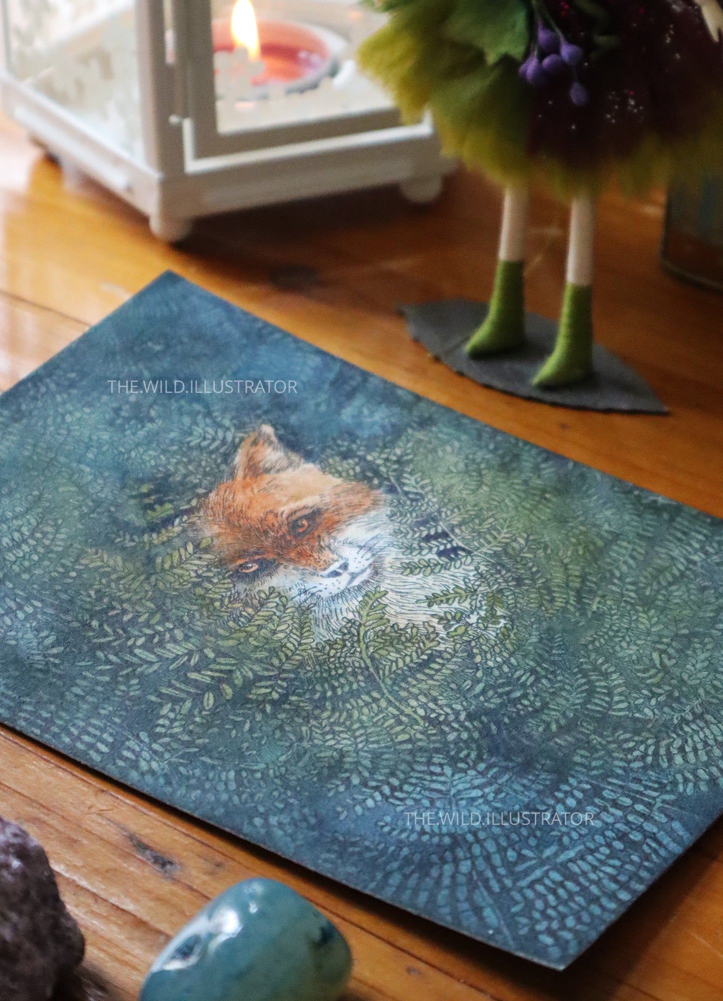 Hand-painted watercolor artwork of a fox resting among green ferns, symbolizing intuition, transformation, and adaptability, on 100% cotton Fabriano paper.