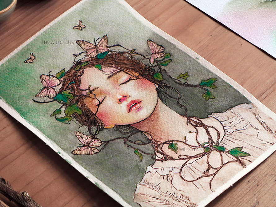 Original watercolor painting featuring a serene woman entwined with vines and golden butterflies on Fabriano 100% cotton paper. Symbolic of harmony with nature.